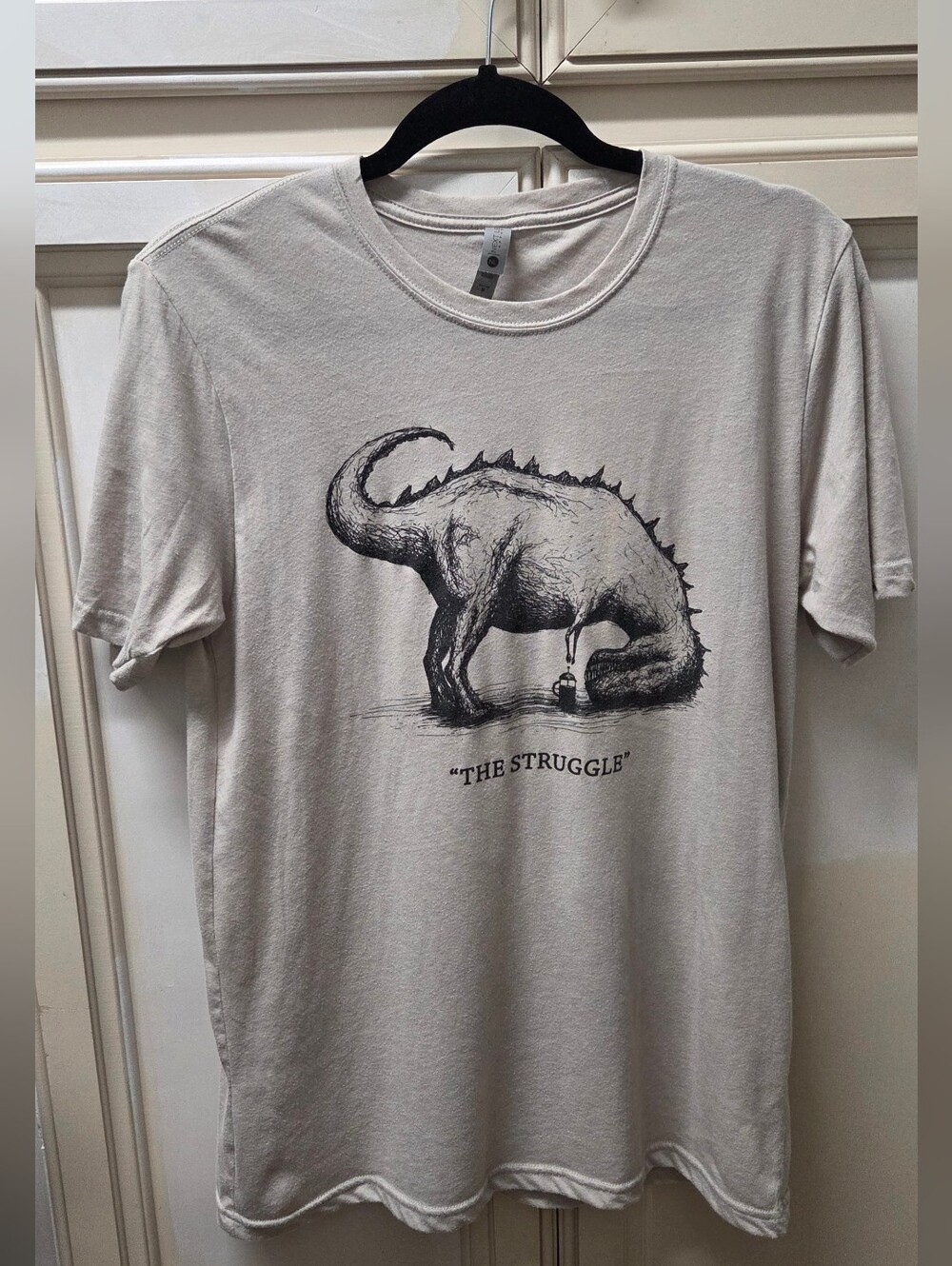 Graphic 'The Struggle' Dinosaur Tee in Light Griege Grey Biege Size M